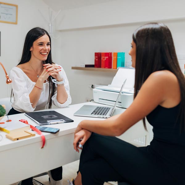 woman speaking to another woman in office